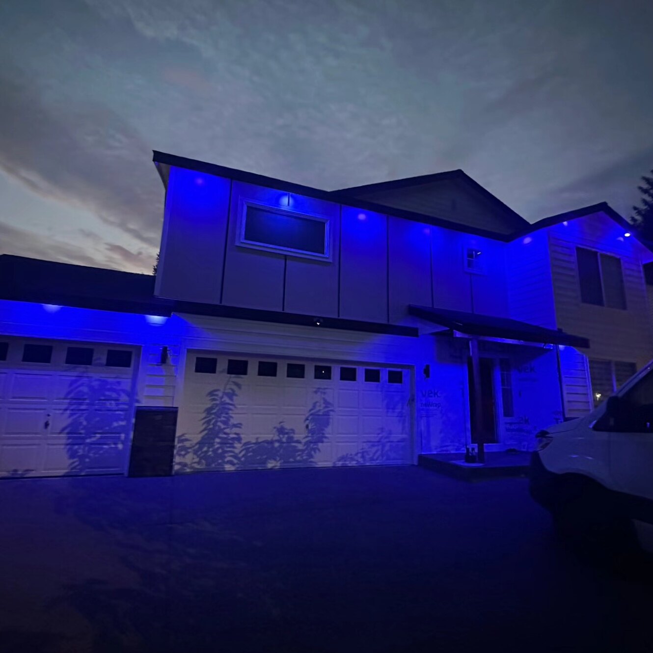 House exterior at night with soffit lighting set to a vivid blue color-changing mode