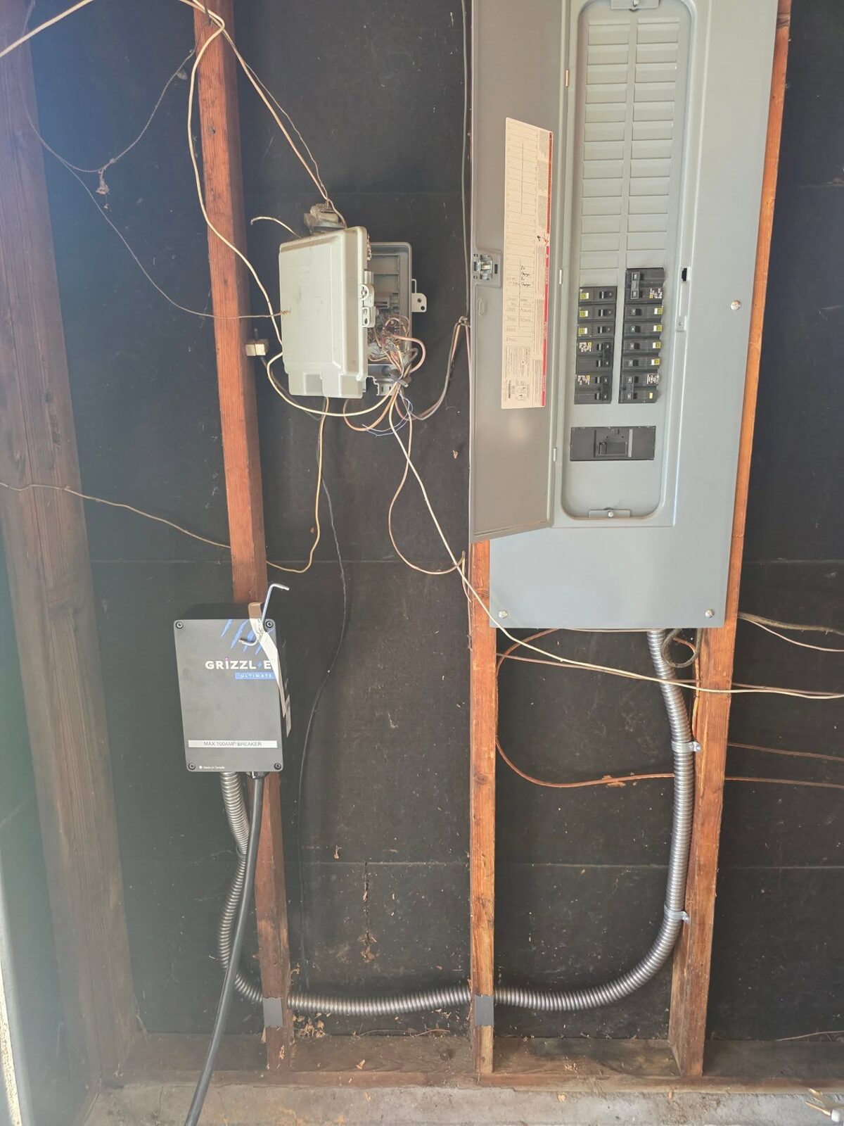 A load-managed Level 2 EV charger wired into conduit and run to a labeled EV Charger breaker